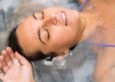 Woman floating peacefully with eyes closed during a float therapy session