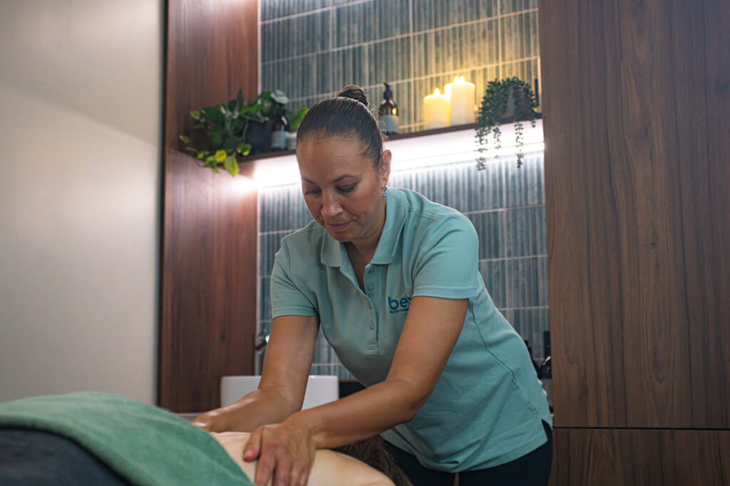 A being therapist giving a back massage in a treatment room in St Albans